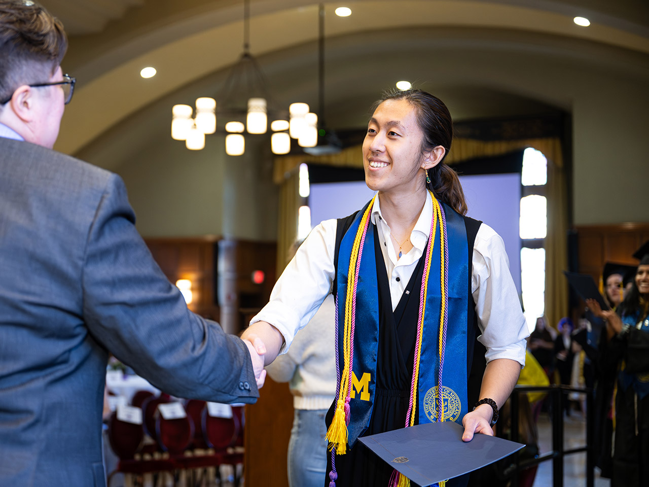 A Lavender Graduate shakes the hand of Spectrum Center director Jesse Beal