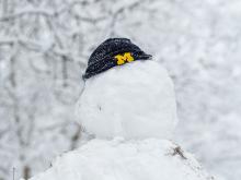 A snowman wearing a U-M beanie hat