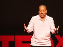 Audience point-of-view of Angie Freeman on stage at TEDx Oshkosh, speaking emphatically