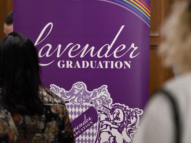 attendees approach the lavender graduation check-in station and signage