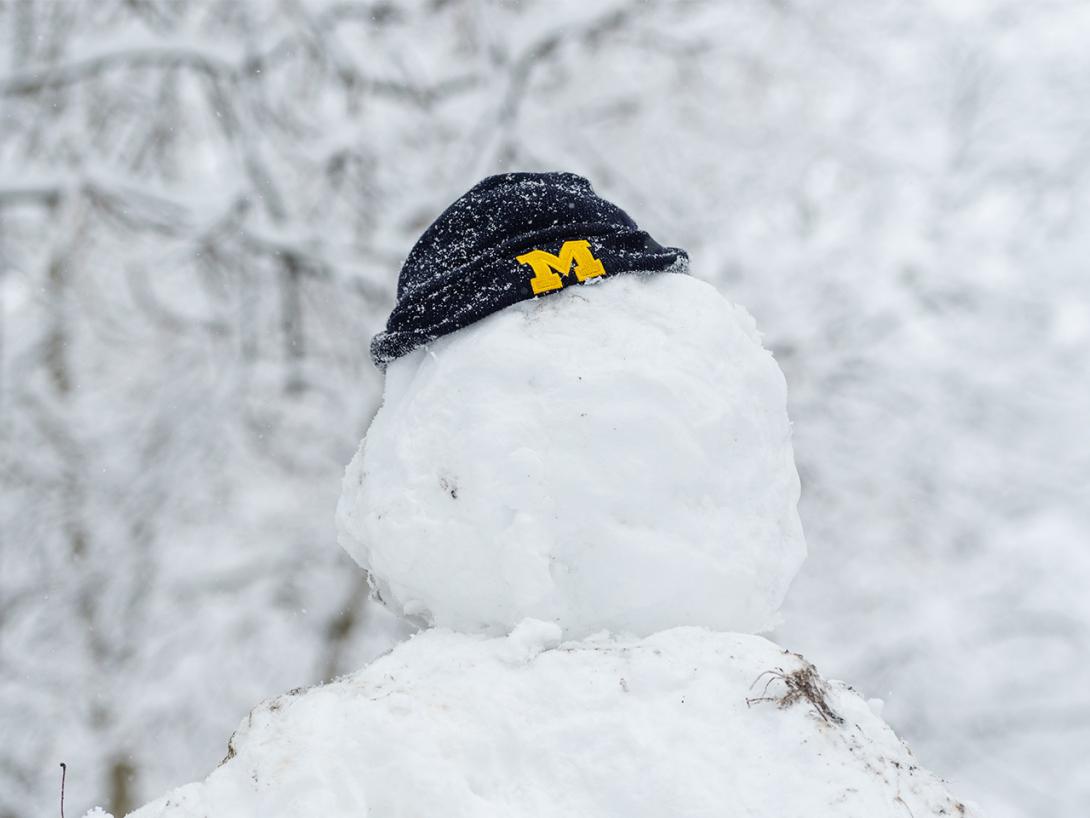 A snowman wearing a U-M beanie hat